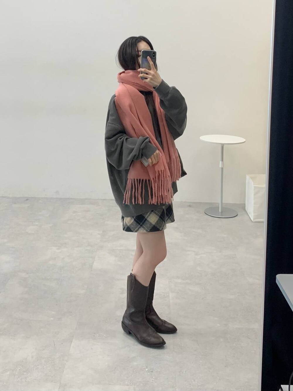 ブラック系のスカート、ブラック系のハンドバッグ、グレー系のスウェットを着用したレディースの冬コーディネートの2枚目の写真