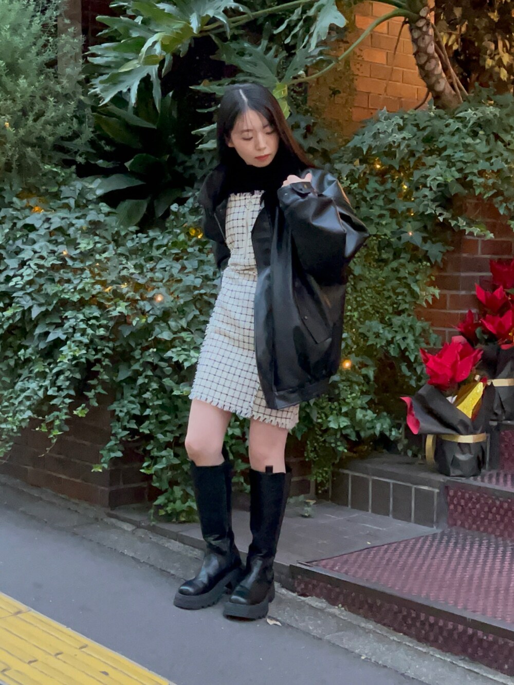 ブラック系のブーツ、ブラック系のブルゾン、ホワイト系のワンピースを着用したレディースの冬コーディネートの2枚目の写真