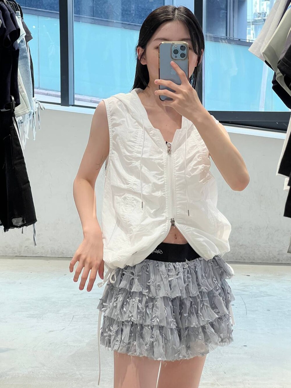 ホワイト系のスカート、ホワイト系のベストを着用したレディースの夏コーディネートの3枚目の写真