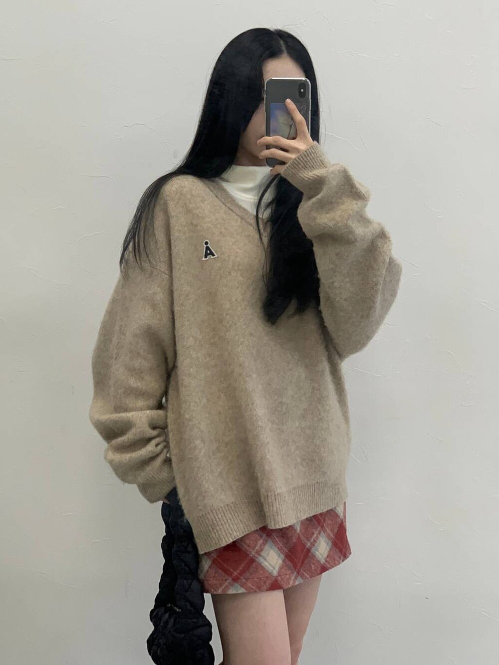 ブラック系のショルダーバッグ、レッド系のスカート、ベージュ系のTシャツ/カットソーを着用したレディースの冬コーディネートの5枚目の写真