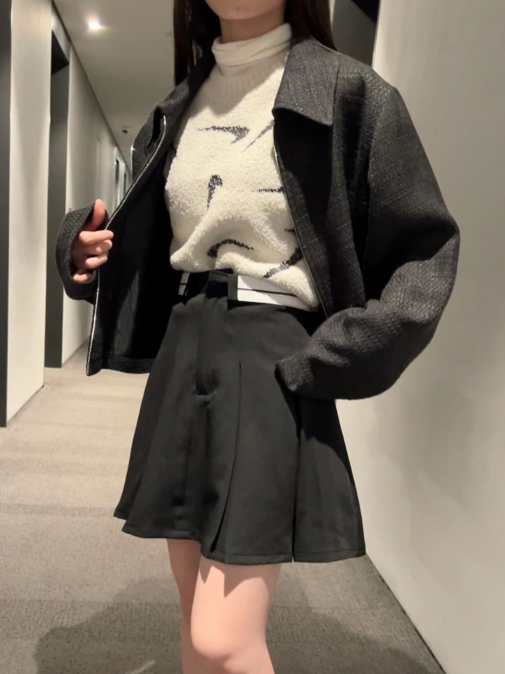 ブラック系のスカート、ブラック系のブルゾン、ブラウン系のTシャツ/カットソーを着用したレディースの春コーディネートの5枚目の写真