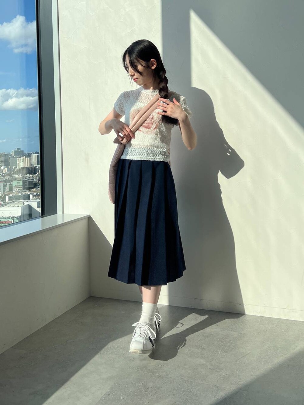 ブルー系のスカート、ホワイト系のTシャツ/カットソー、ピンク系のショルダーバッグを着用したレディースの夏コーディネートの2枚目の写真