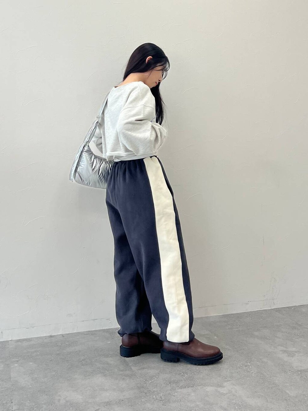 グレー系のTシャツ/カットソー、その他のショルダーバッグ、グレー系のスウェットパンツを着用したレディースの冬コーディネートの3枚目の写真