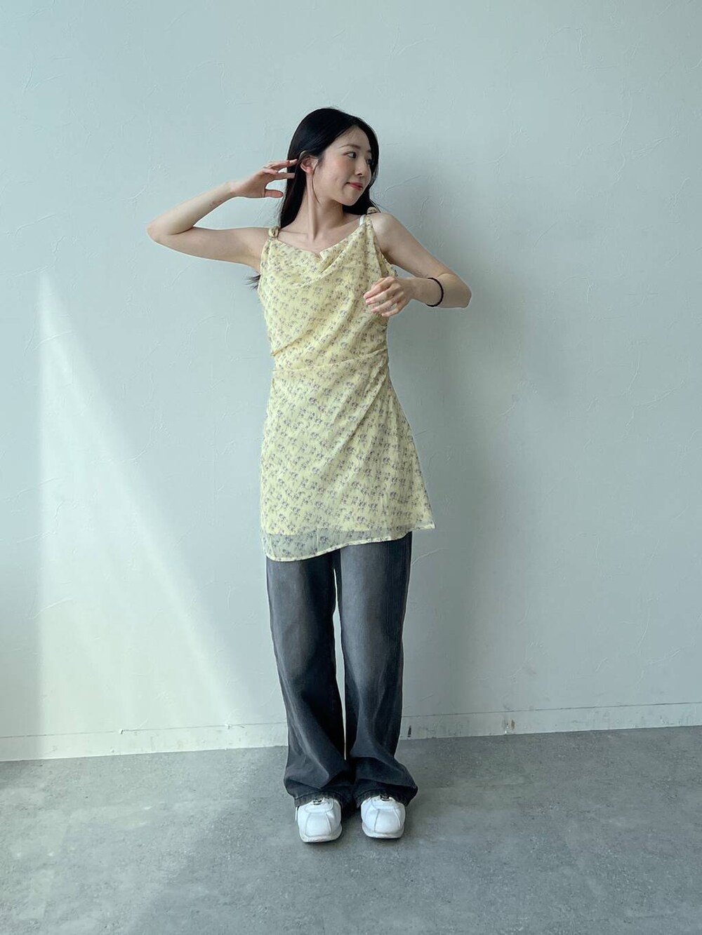 イエロー系のワンピース、ブラック系のトートバッグ、ブラック系のカーディガン/ボレロを着用したレディースの夏コーディネートの2枚目の写真