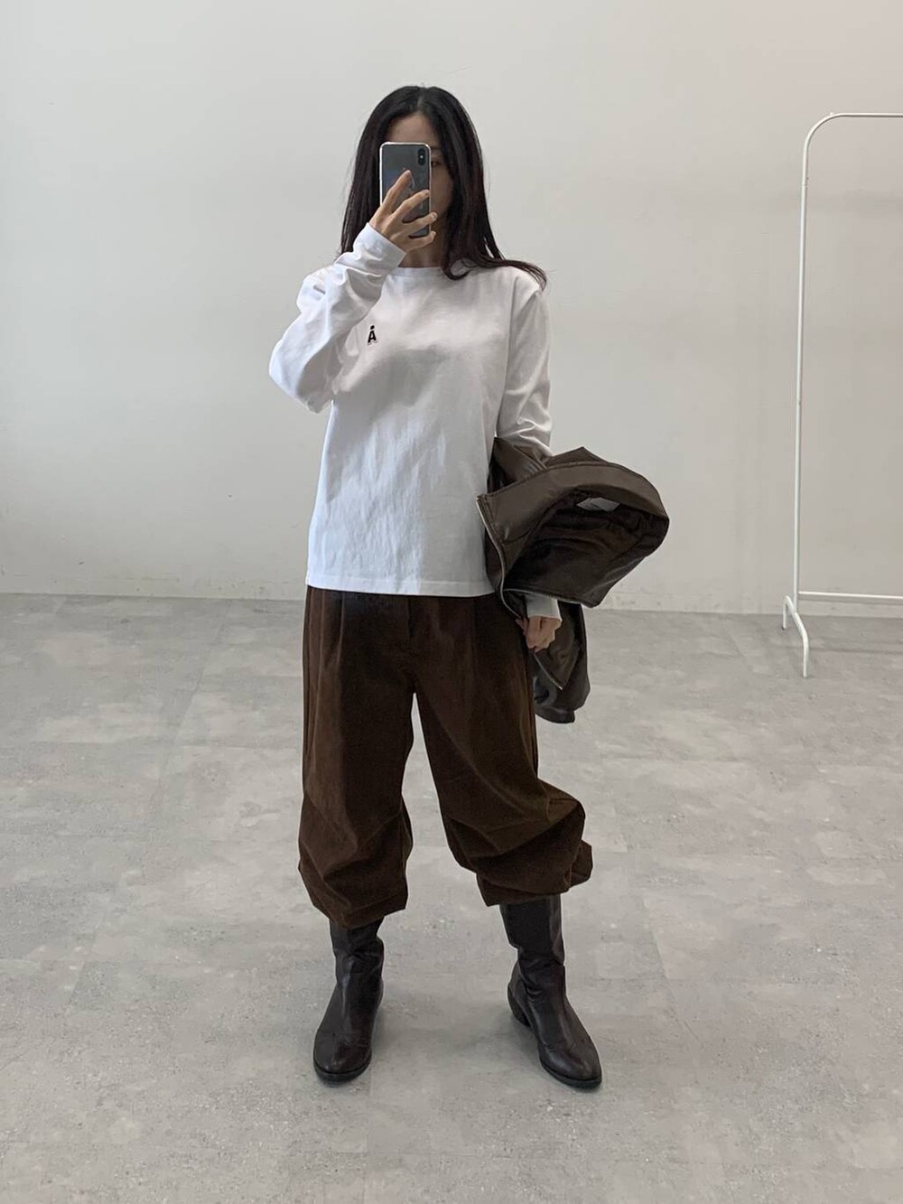 ブラウン系のブルゾン、ブラウン系のその他パンツ、グレー系のマフラーを着用したレディースの秋コーディネートの6枚目の写真