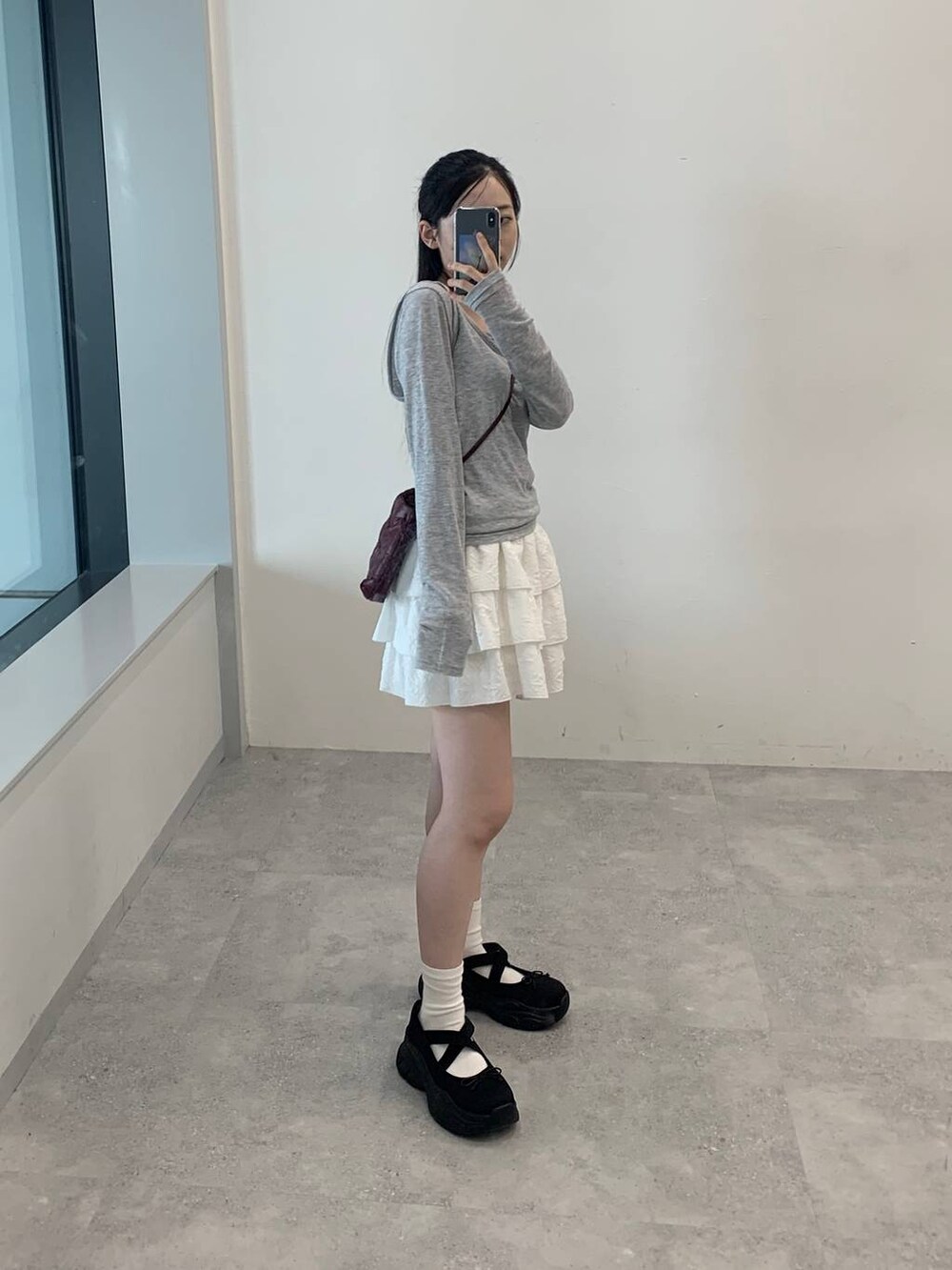 ホワイト系のスカート、グレー系のTシャツ/カットソーを着用したレディースの秋コーディネートの2枚目の写真