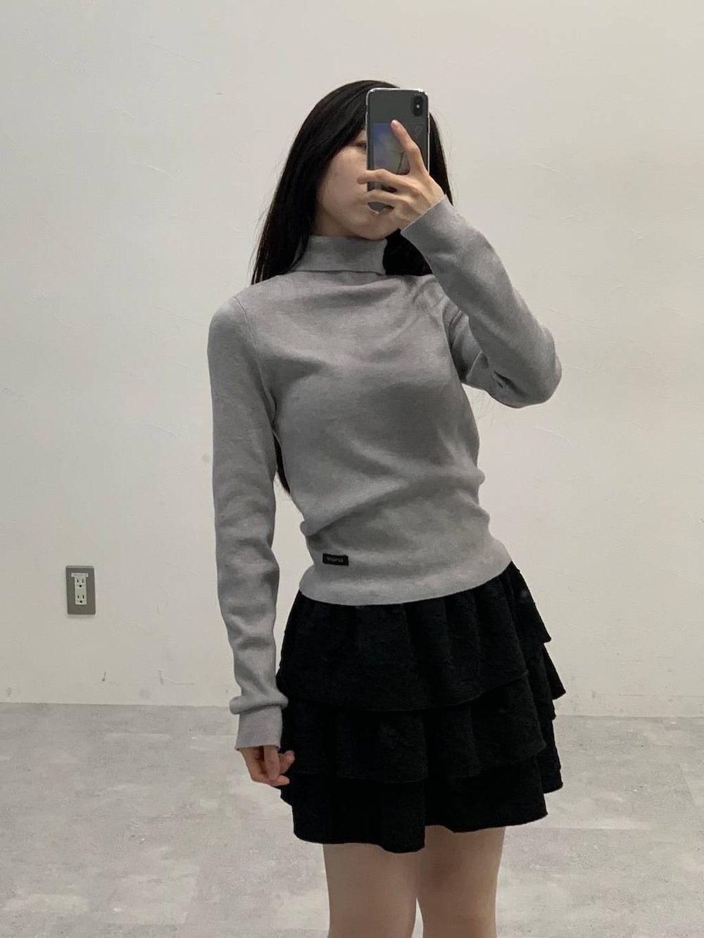 ブラック系のサンダル、ブラック系のスカート、ブラウン系のブルゾンを着用したレディースの秋コーディネートの5枚目の写真