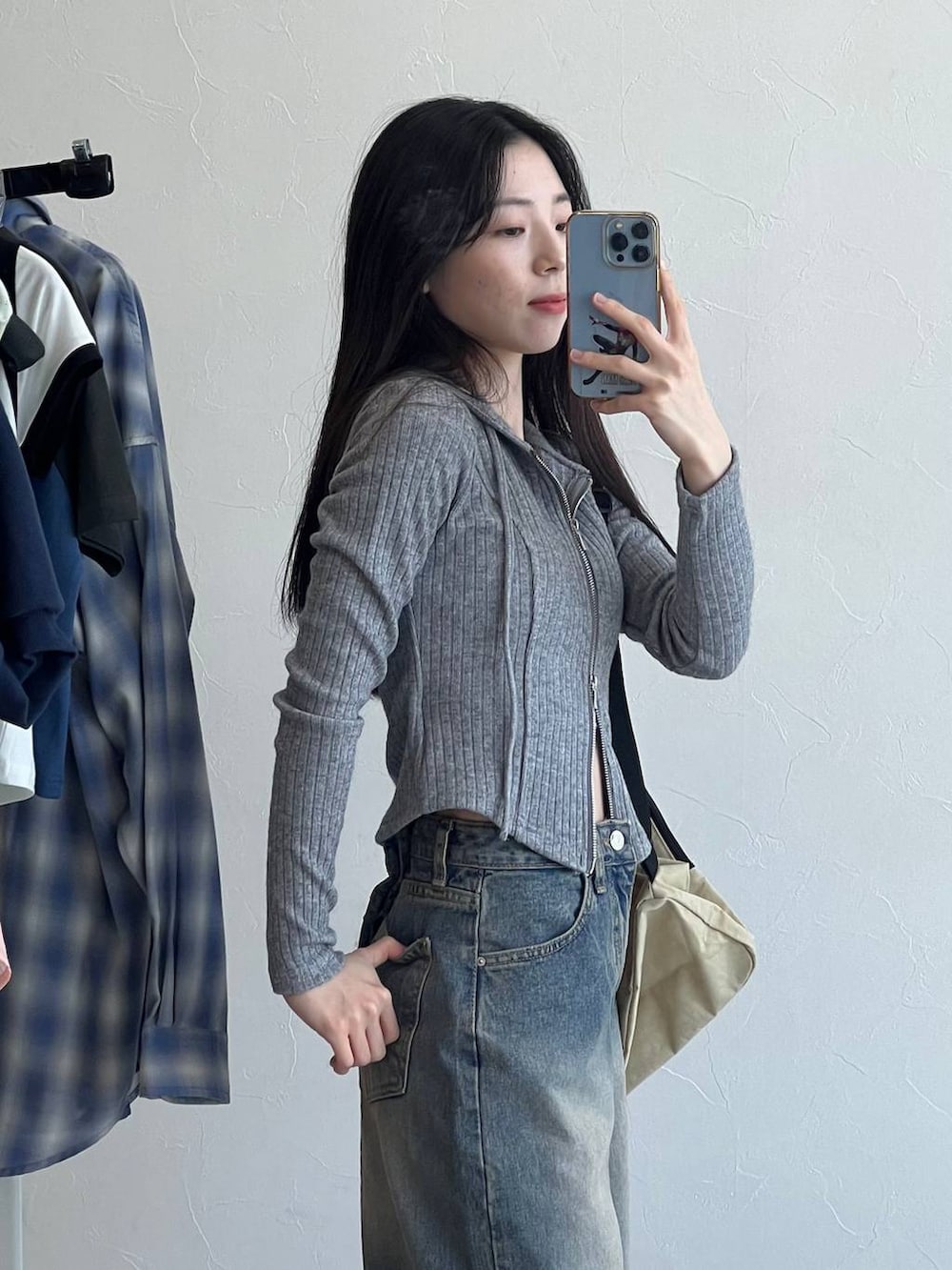 ブルー系のデニムパンツ、グレー系のTシャツ/カットソー、ベージュ系のバックパック/リュックを着用したレディースの春コーディネートの6枚目の写真