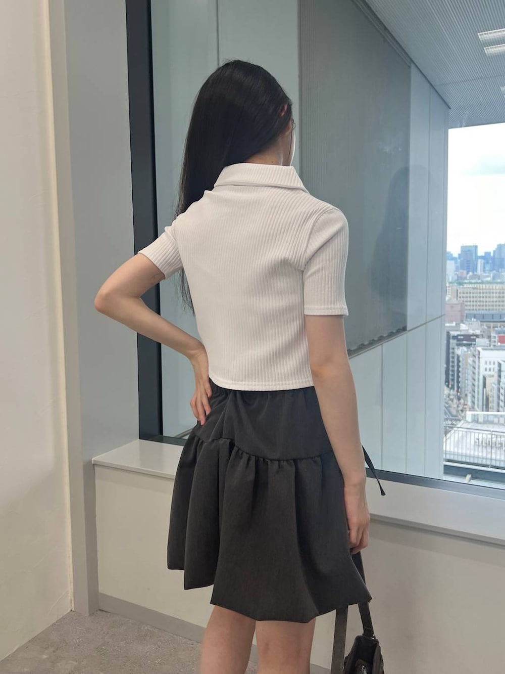 グレー系のスカート、ブラック系のトートバッグ、ホワイト系のカーディガン/ボレロを着用したレディースの夏コーディネートの6枚目の写真