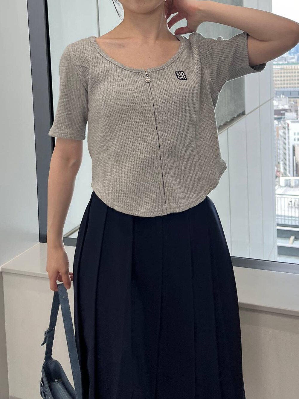 ブルー系のスカート、ブルー系のトートバッグ、グレー系のTシャツ/カットソーを着用したレディースの夏コーディネートの6枚目の写真