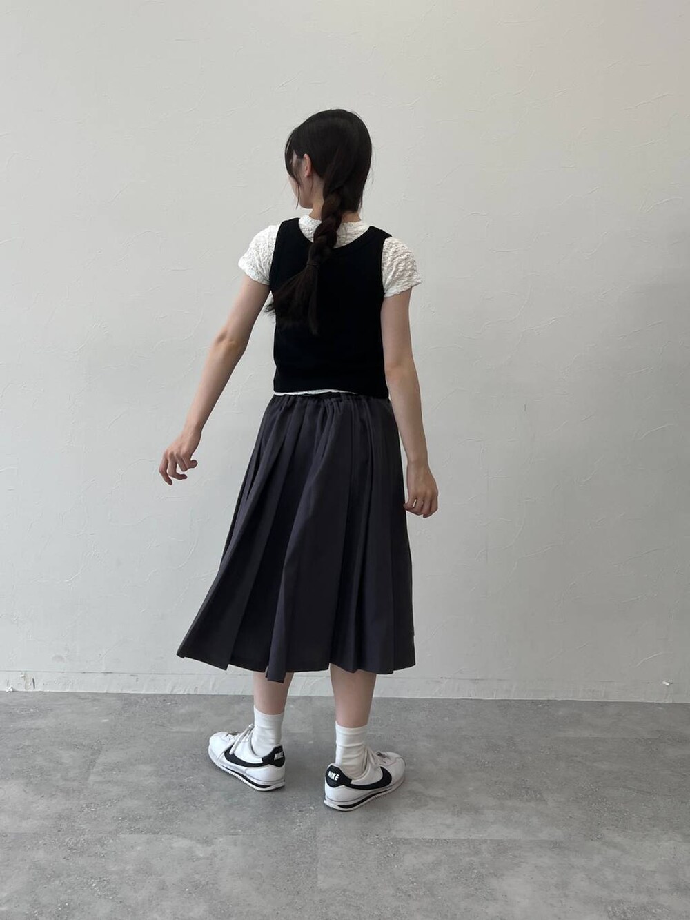 グレー系のスカート、ブラック系のタンクトップ、ホワイト系のTシャツ/カットソーを着用したレディースの夏コーディネートの4枚目の写真