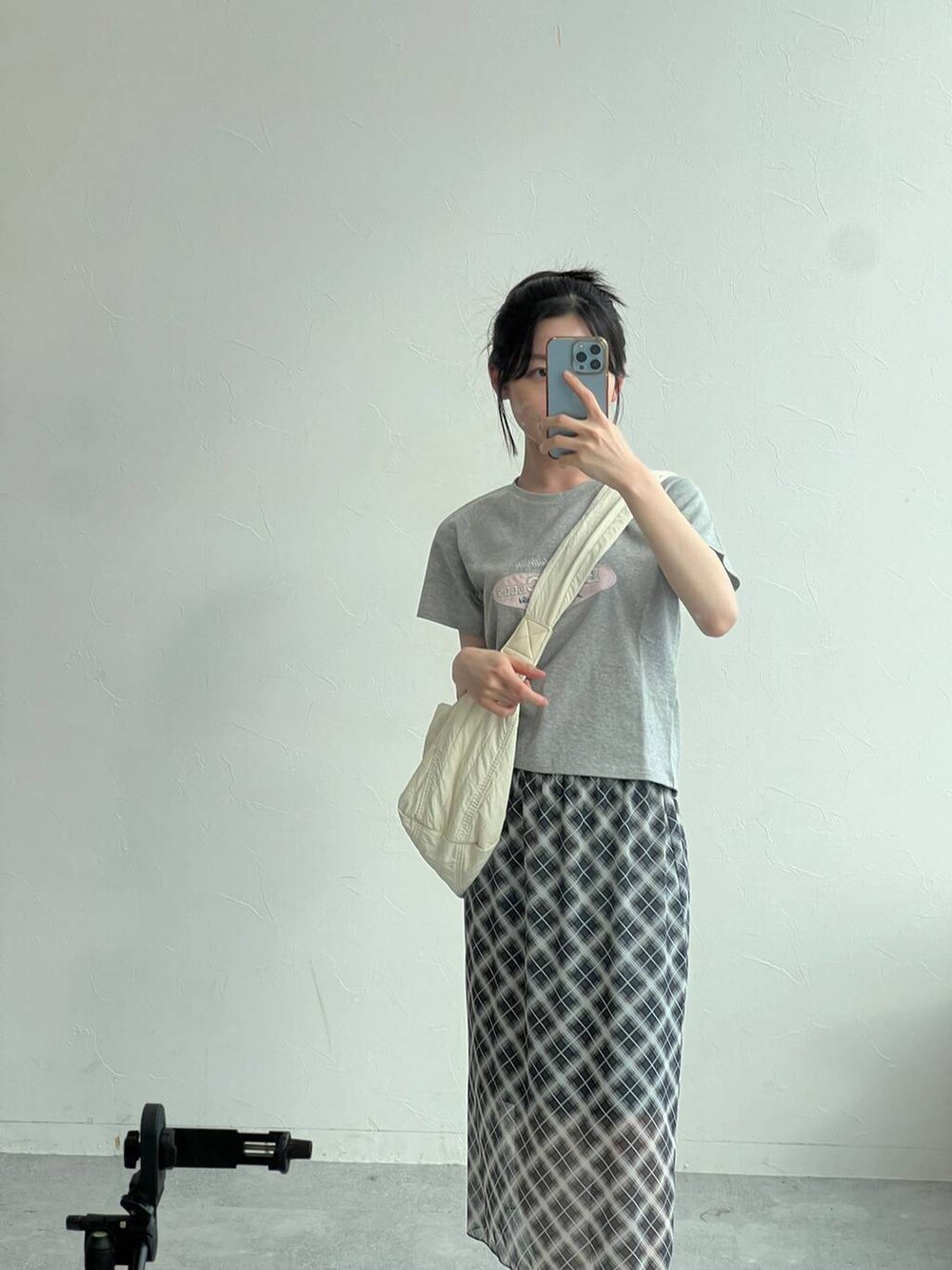 グレー系のTシャツ/カットソー、グレー系のスカート、ベージュ系のショルダーバッグを着用したレディースの夏コーディネートの6枚目の写真