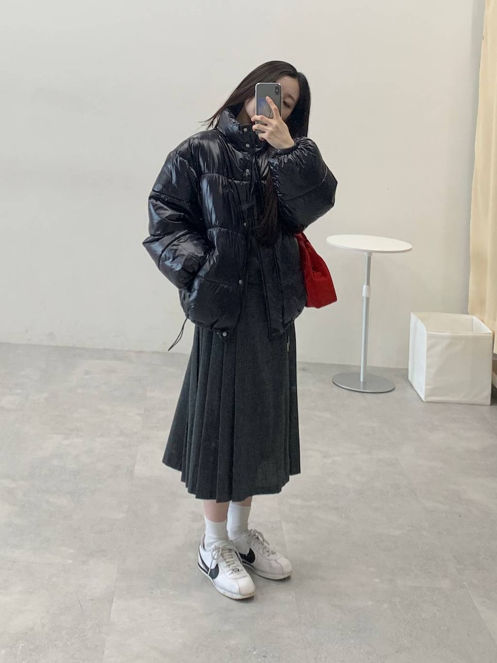 ブラック系のダウンジャケット/コート、グレー系のスカート、グレー系のTシャツ/カットソーを着用したレディースの冬コーディネートの6枚目の写真