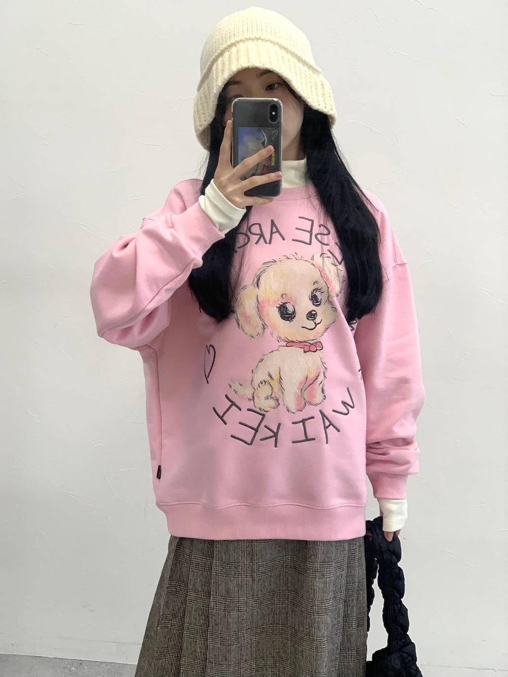 ブラック系のショルダーバッグ、ブラウン系のスカート、ピンク系のスウェットを着用したレディースの冬コーディネートの6枚目の写真