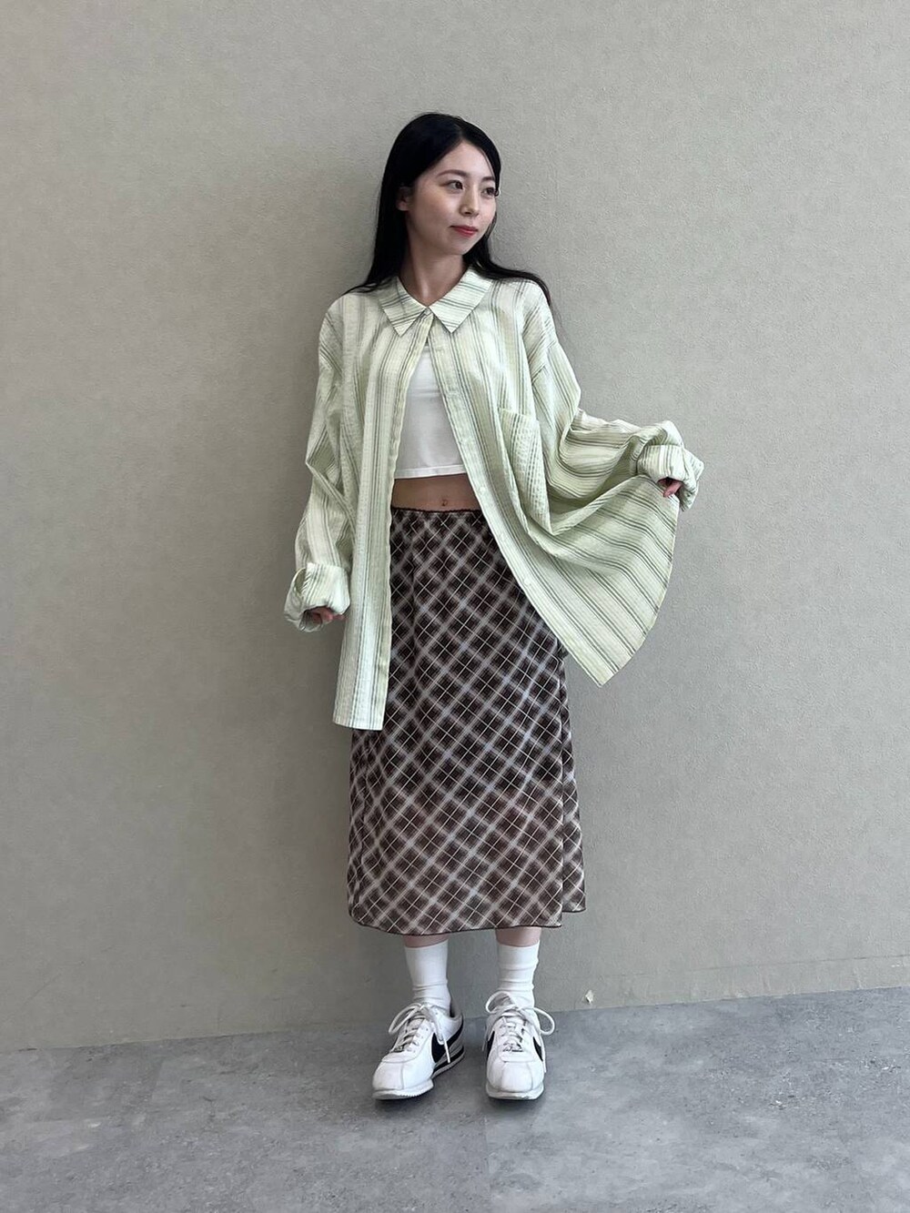 ブラウン系のスカート、グリーン系のシャツ/ブラウスを着用したレディースの夏コーディネートの4枚目の写真