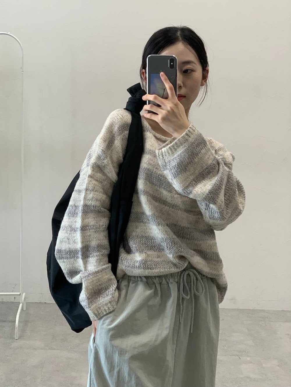 グレー系のその他パンツ、ブラック系のショルダーバッグ、グレー系のニット/セーターを着用したレディースの秋コーディネートの4枚目の写真