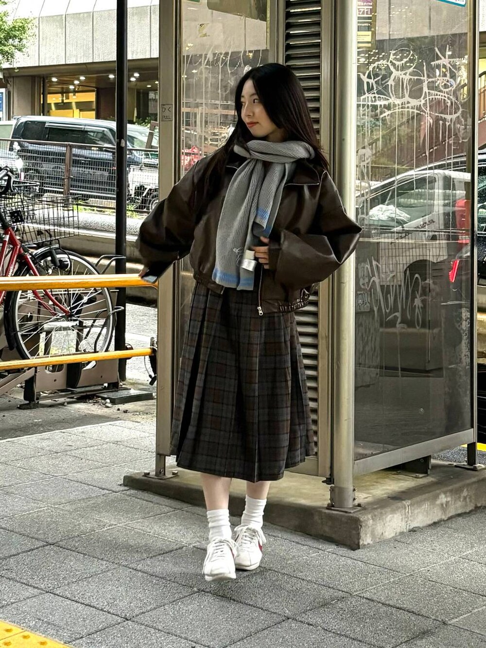 グレー系のカーディガン/ボレロ、ブラウン系のブルゾン、ブラウン系のスカートを着用したレディースの秋コーディネートの7枚目の写真