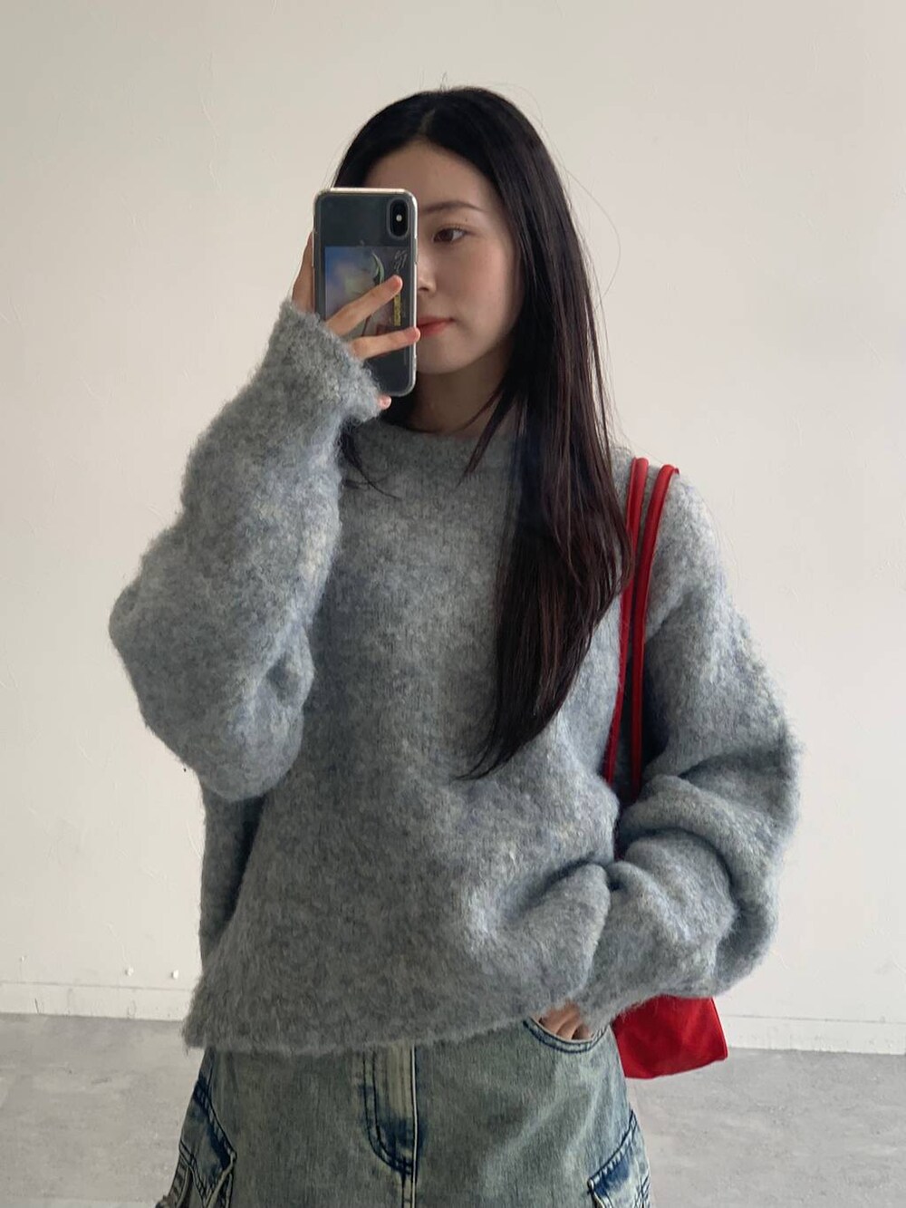 ブルー系のデニムスカート、グレー系のニット/セーターを着用したレディースの秋コーディネートの9枚目の写真