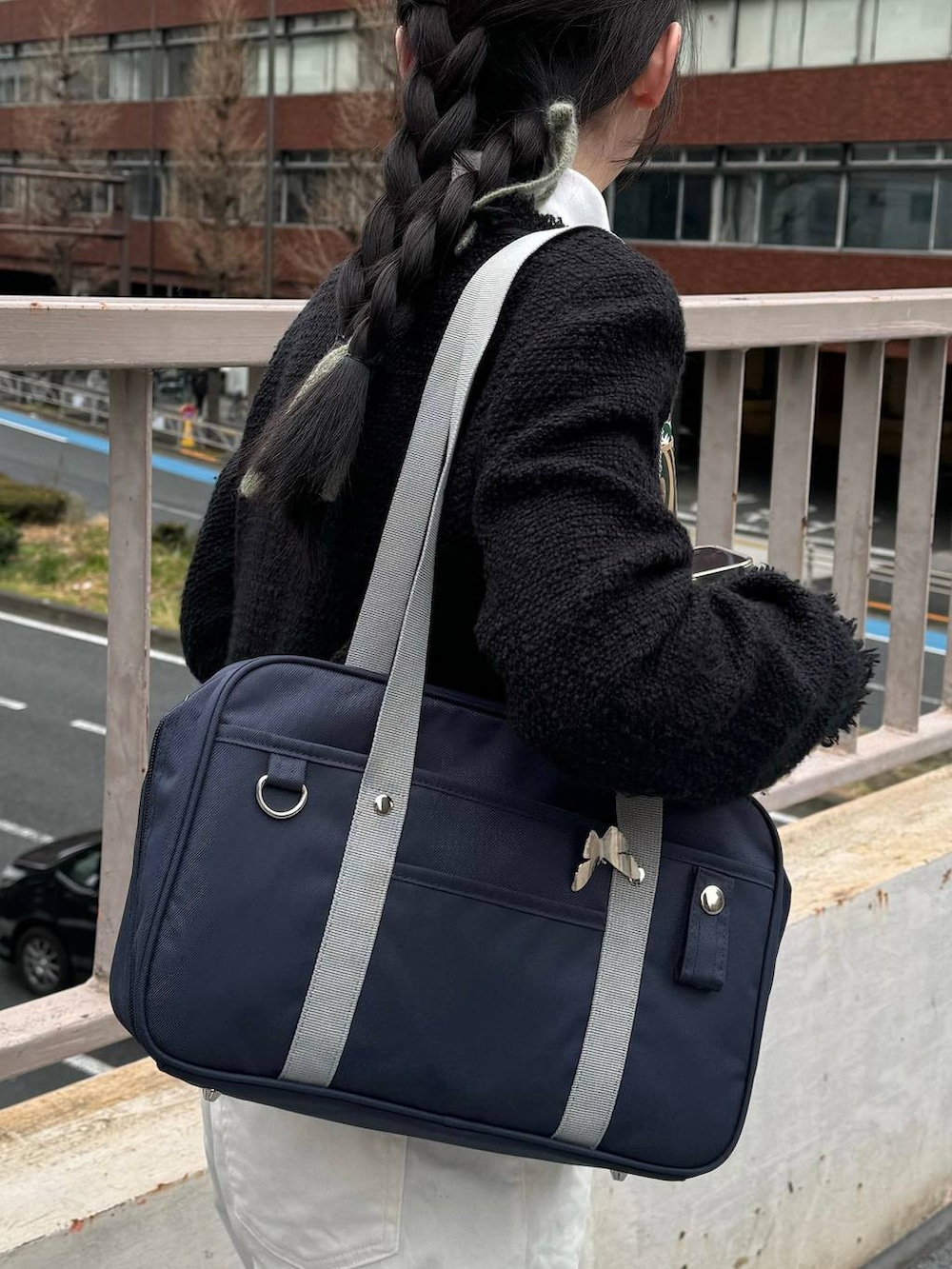 ブルー系のトートバッグ、ブラック系のジャケット/アウター、ホワイト系のTシャツ/カットソーを着用したレディースの冬コーディネートの3枚目の写真