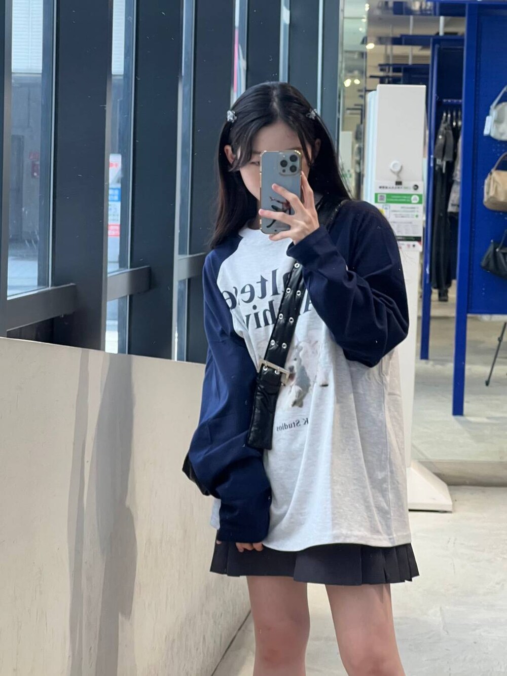 グレー系のスカート、ブラック系のショルダーバッグ、グレー系のTシャツ/カットソーを着用したレディースの春コーディネートの3枚目の写真