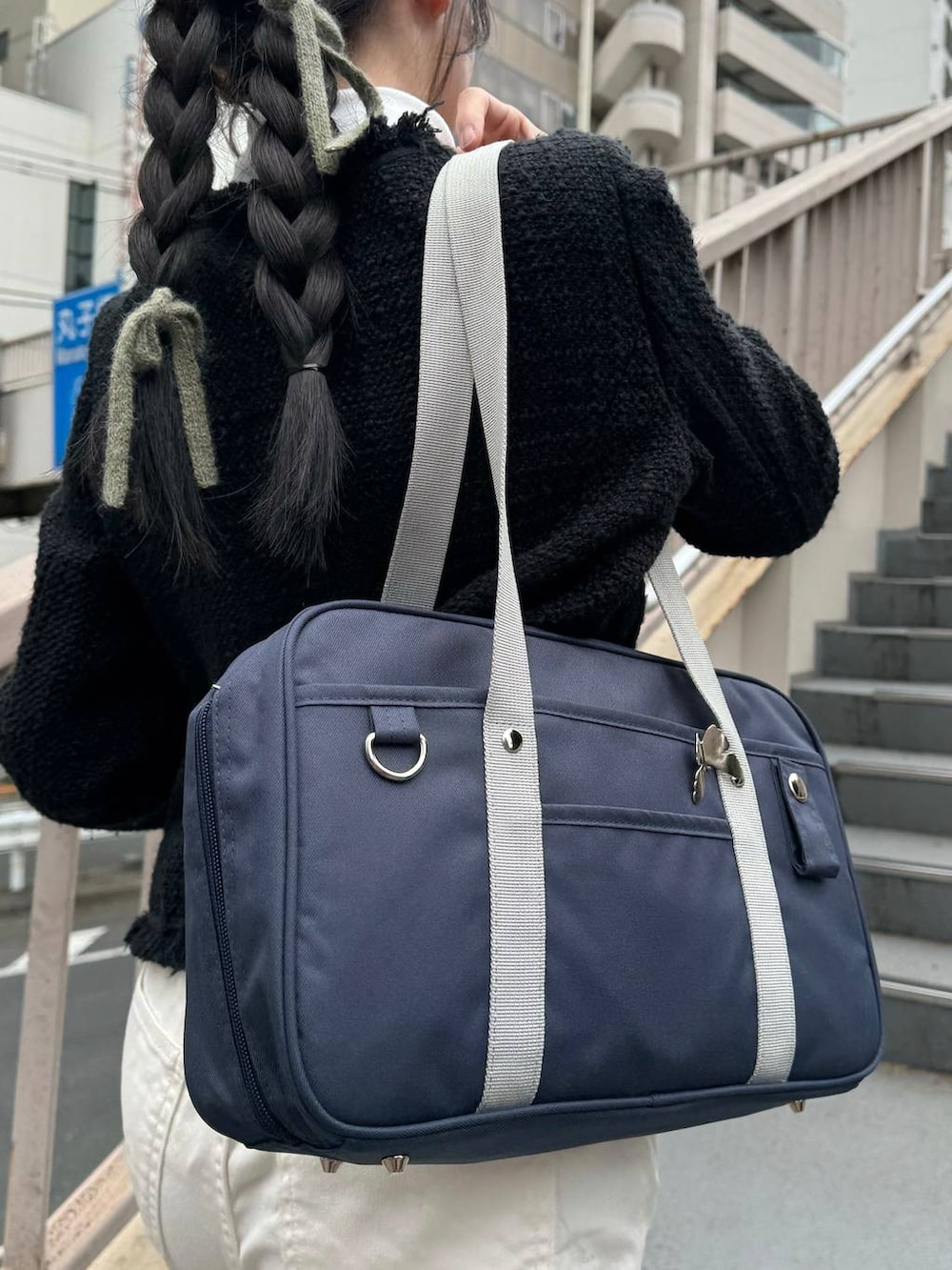 ブルー系のトートバッグ、ブラック系のジャケット/アウター、ホワイト系のTシャツ/カットソーを着用したレディースの冬コーディネートの4枚目の写真