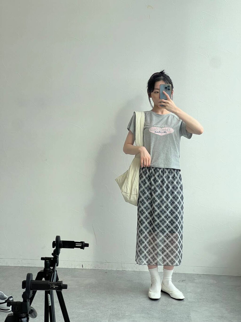 グレー系のTシャツ/カットソー、グレー系のスカート、ベージュ系のショルダーバッグを着用したレディースの夏コーディネートの2枚目の写真