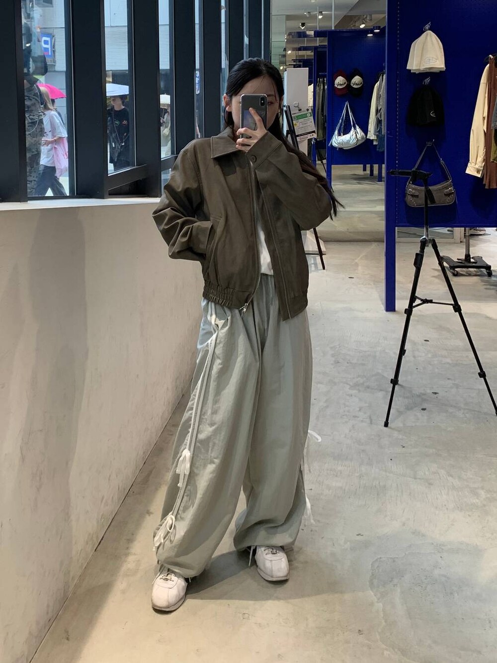 グレー系のその他パンツ、ホワイト系のTシャツ/カットソー、ブラウン系のライダースジャケットを着用したレディースの秋コーディネートの3枚目の写真