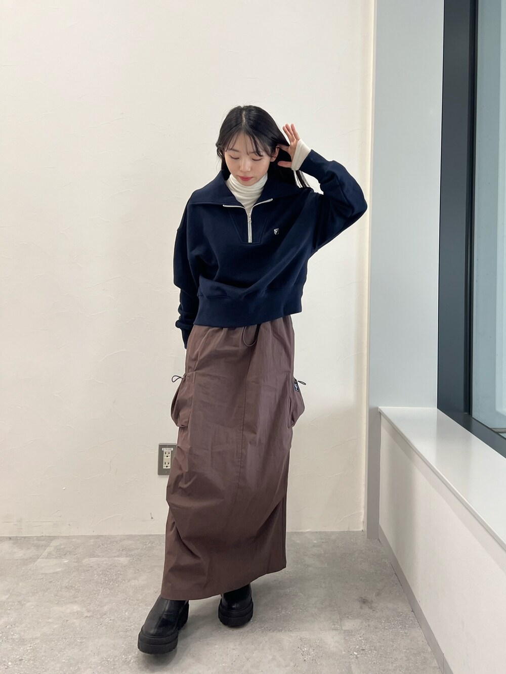 ブルー系のスウェット、ベージュ系のTシャツ/カットソー、ブラウン系のスカートを着用したレディースの冬コーディネートの2枚目の写真