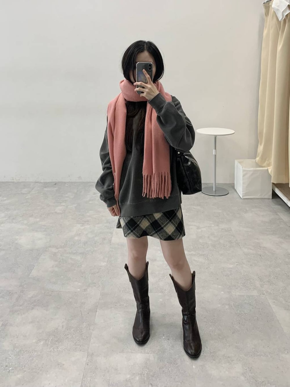 ブラック系のスカート、ブラック系のハンドバッグ、グレー系のスウェットを着用したレディースの冬コーディネートの3枚目の写真