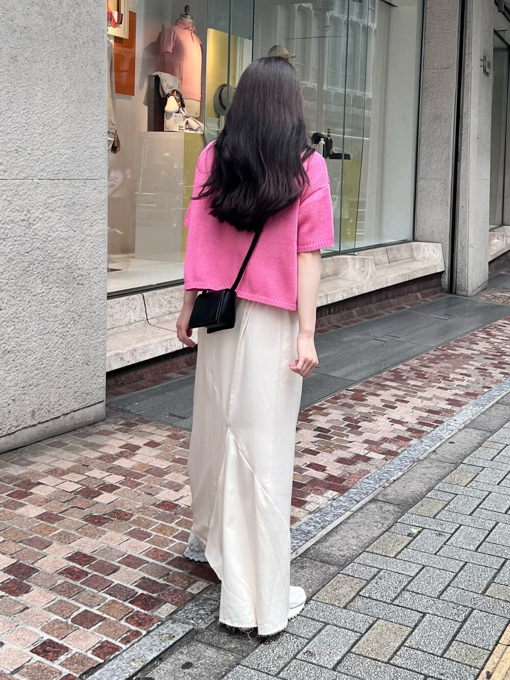 ホワイト系のスニーカー、ピンク系のニット/セーター、ブラック系のショルダーバッグを着用したレディースの夏コーディネートの3枚目の写真