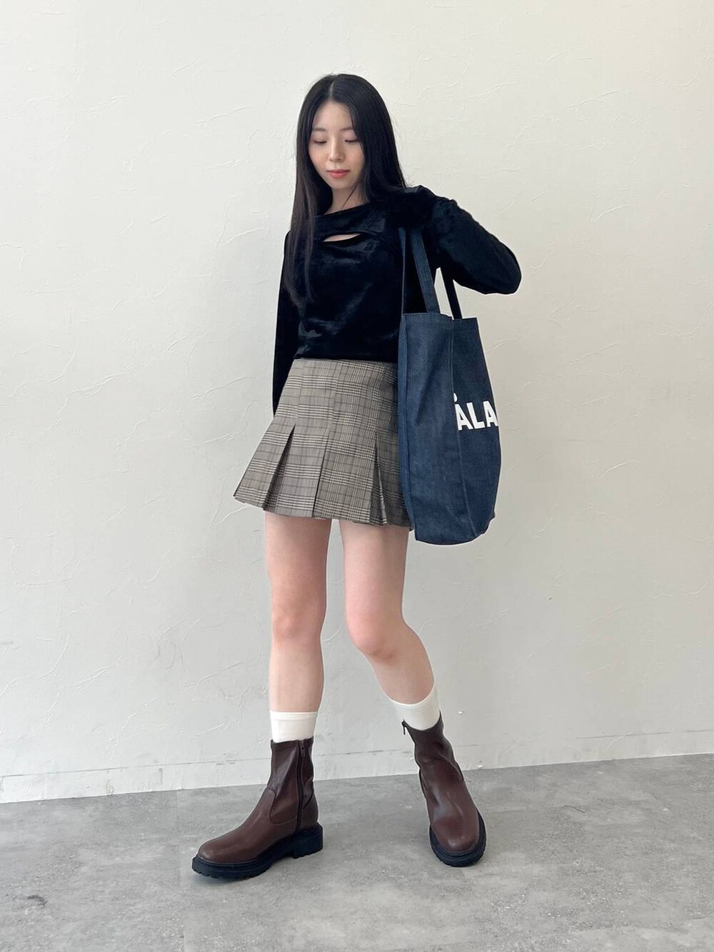 ブラック系のTシャツ/カットソー、ブラウン系のスカート、ブルー系のトートバッグを着用したレディースの冬コーディネートの2枚目の写真