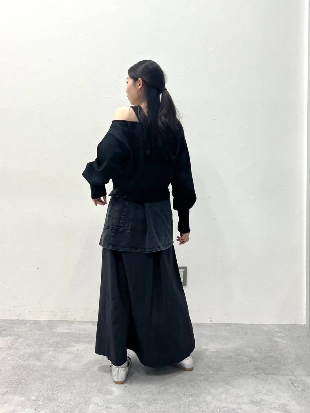 ブラック系のスカート、ブラック系のデニムパンツを着用したレディースの春コーディネートの5枚目の写真