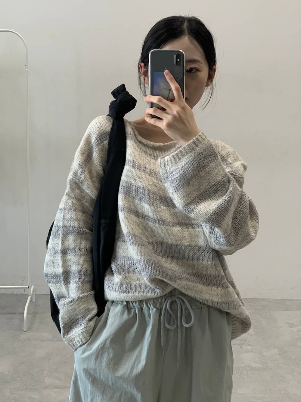 グレー系のその他パンツ、ブラック系のショルダーバッグ、グレー系のニット/セーターを着用したレディースの秋コーディネートの7枚目の写真