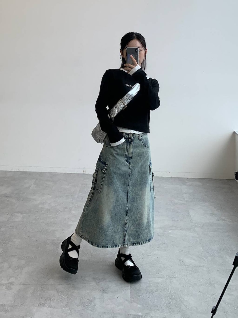 その他のショルダーバッグ、ブルー系のデニムスカート、ブラック系のTシャツ/カットソーを着用したレディースの秋コーディネートの2枚目の写真