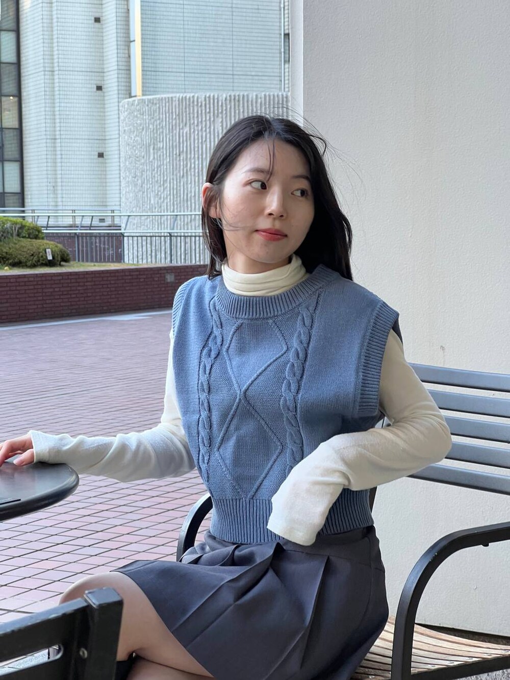 ブルー系のベスト、ブラック系のブーツ、ベージュ系のTシャツ/カットソーを着用したレディースの冬コーディネートの6枚目の写真