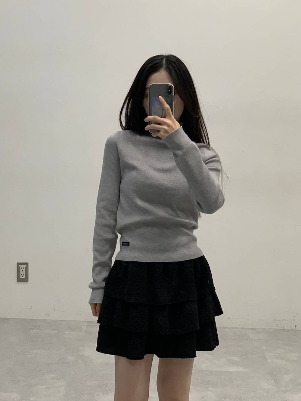 ブラック系のサンダル、ブラック系のスカート、ブラウン系のブルゾンを着用したレディースの秋コーディネートの4枚目の写真
