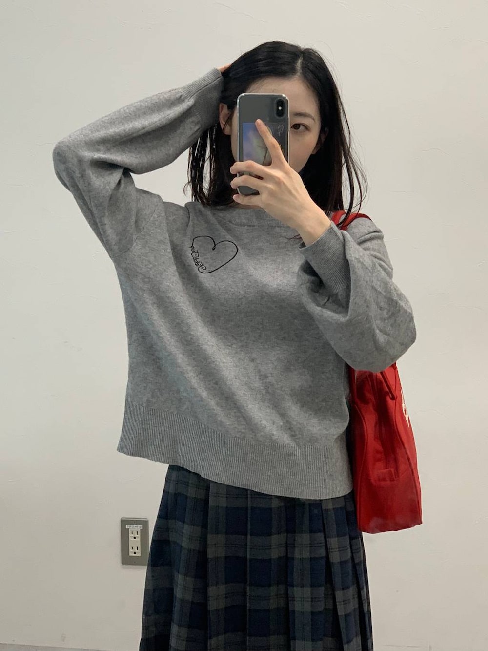 グレー系のニット/セーター、グレー系のスカートを着用したレディースの秋コーディネートの5枚目の写真