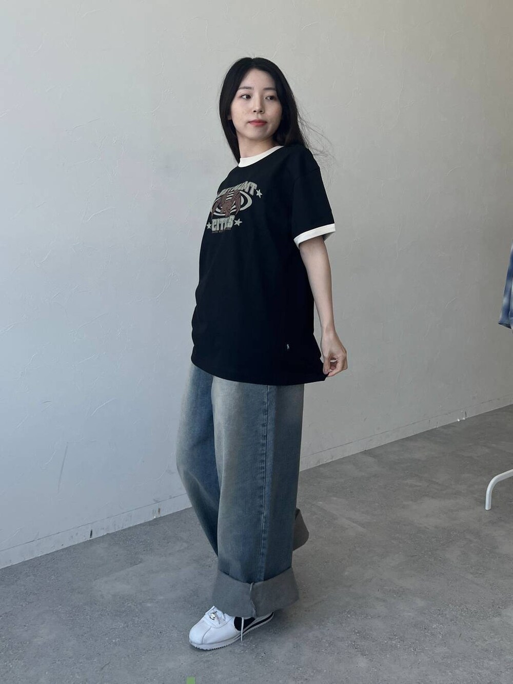 ブルー系のデニムパンツ、ブラック系のTシャツ/カットソーを着用したレディースの春コーディネートの2枚目の写真