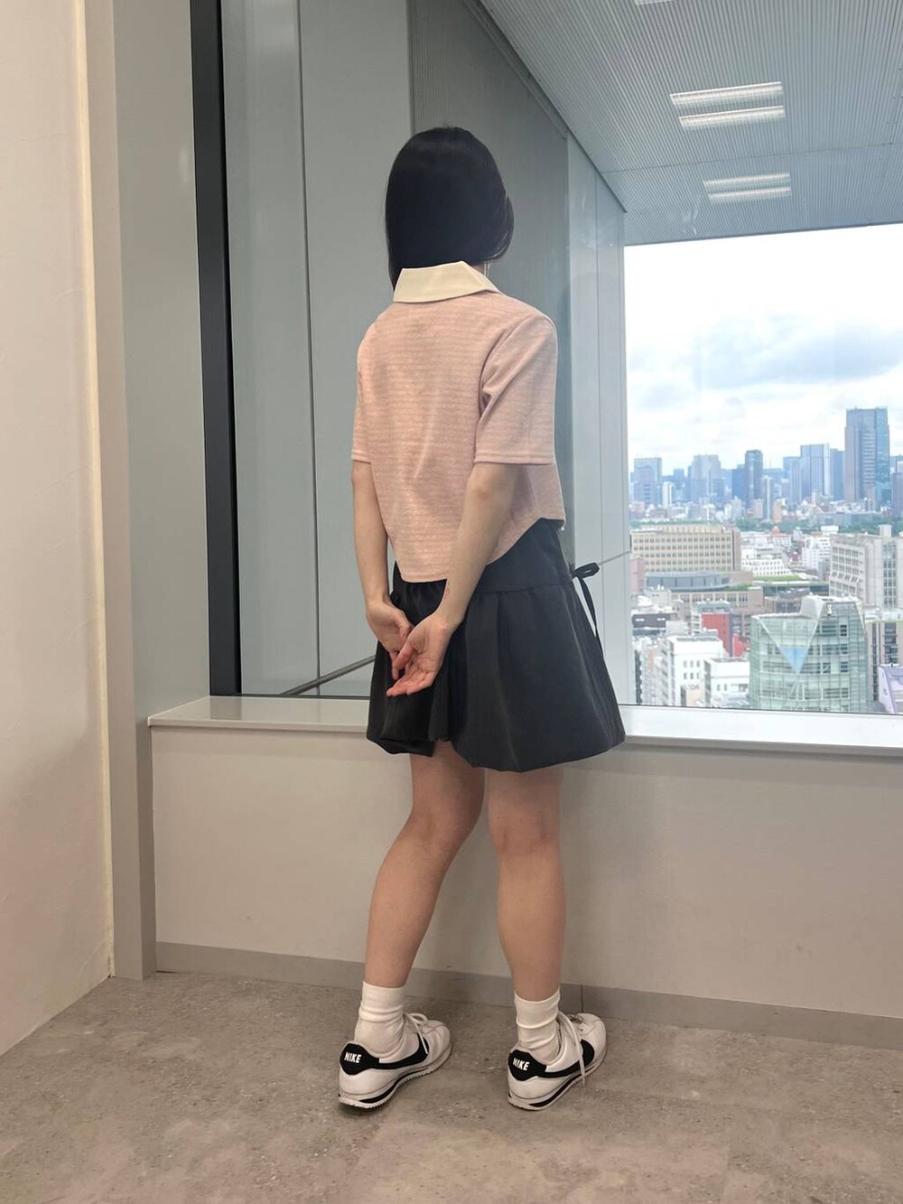 グレー系のスカート、ピンク系のTシャツ/カットソーを着用したレディースの夏コーディネートの2枚目の写真