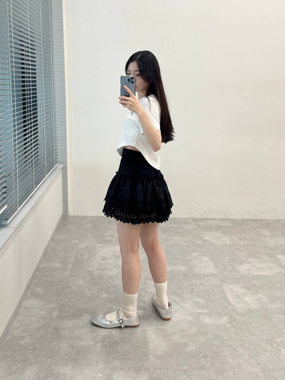 ブラック系のスカート、ホワイト系のTシャツ/カットソーを着用したレディースの春コーディネートの3枚目の写真