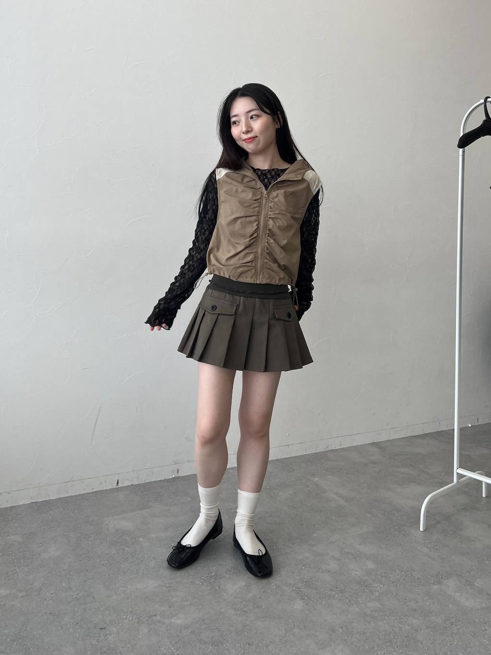 ベージュ系のベスト、ブラック系のTシャツ/カットソーを着用したレディースの春コーディネートの2枚目の写真