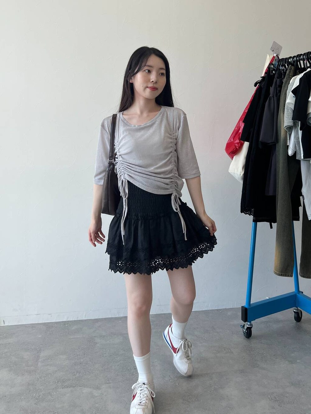 ブラック系のスカート、グレー系のTシャツ/カットソーを着用したレディースの春コーディネートの4枚目の写真