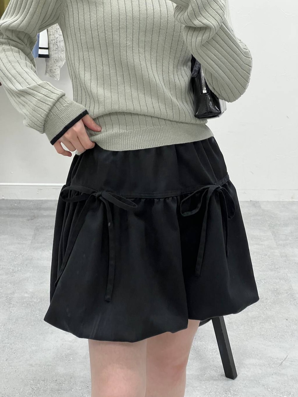 グレー系のTシャツ/カットソー、ブラック系のハンドバッグを着用したレディースの冬コーディネートの7枚目の写真