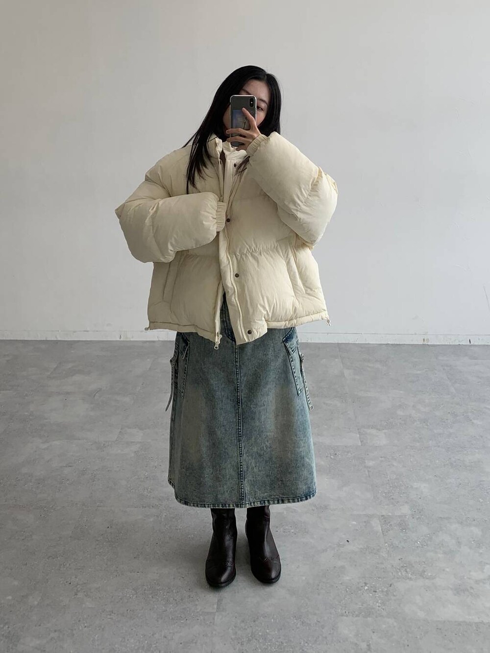 ブルー系のデニムスカート、ベージュ系のダウンジャケット/コートを着用したレディースの秋コーディネートの5枚目の写真
