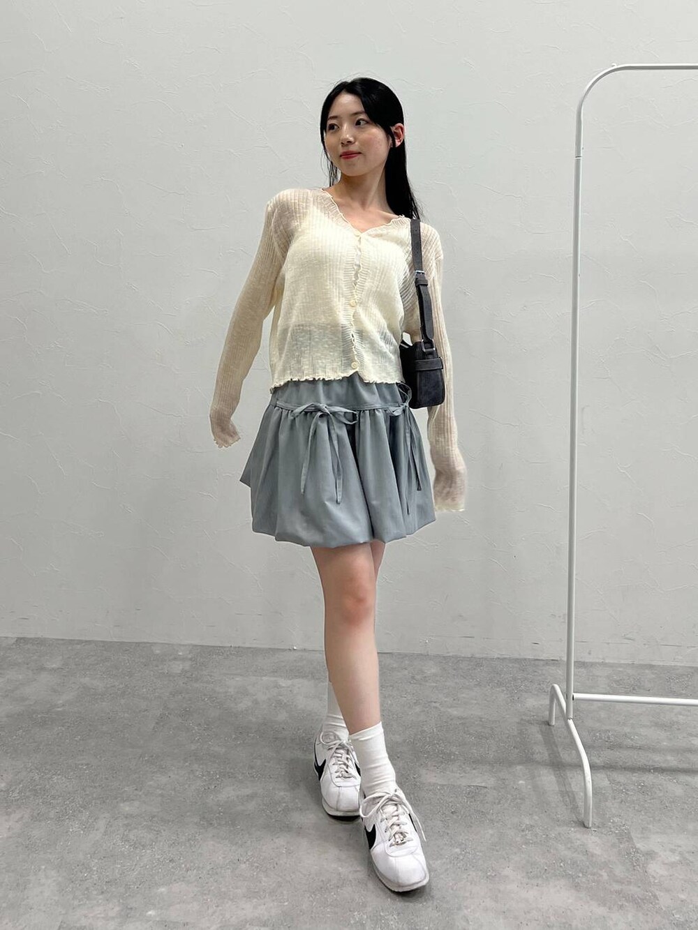 グレー系のスカート、ブラック系のトートバッグ、ベージュ系のカーディガン/ボレロを着用したレディースの夏コーディネートの7枚目の写真