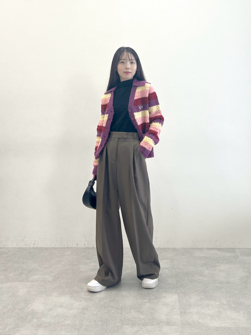 パープル系のカーディガン/ボレロ、ブラック系のTシャツ/カットソー、ブラウン系のスラックスを着用したレディースの冬コーディネートの2枚目の写真