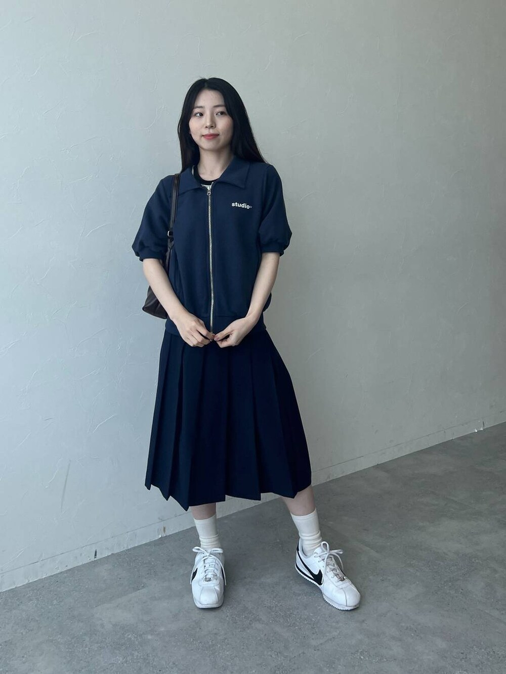 ブルー系のスウェット、ホワイト系のTシャツ/カットソー、ブルー系のスカートを着用したレディースの春コーディネートの2枚目の写真