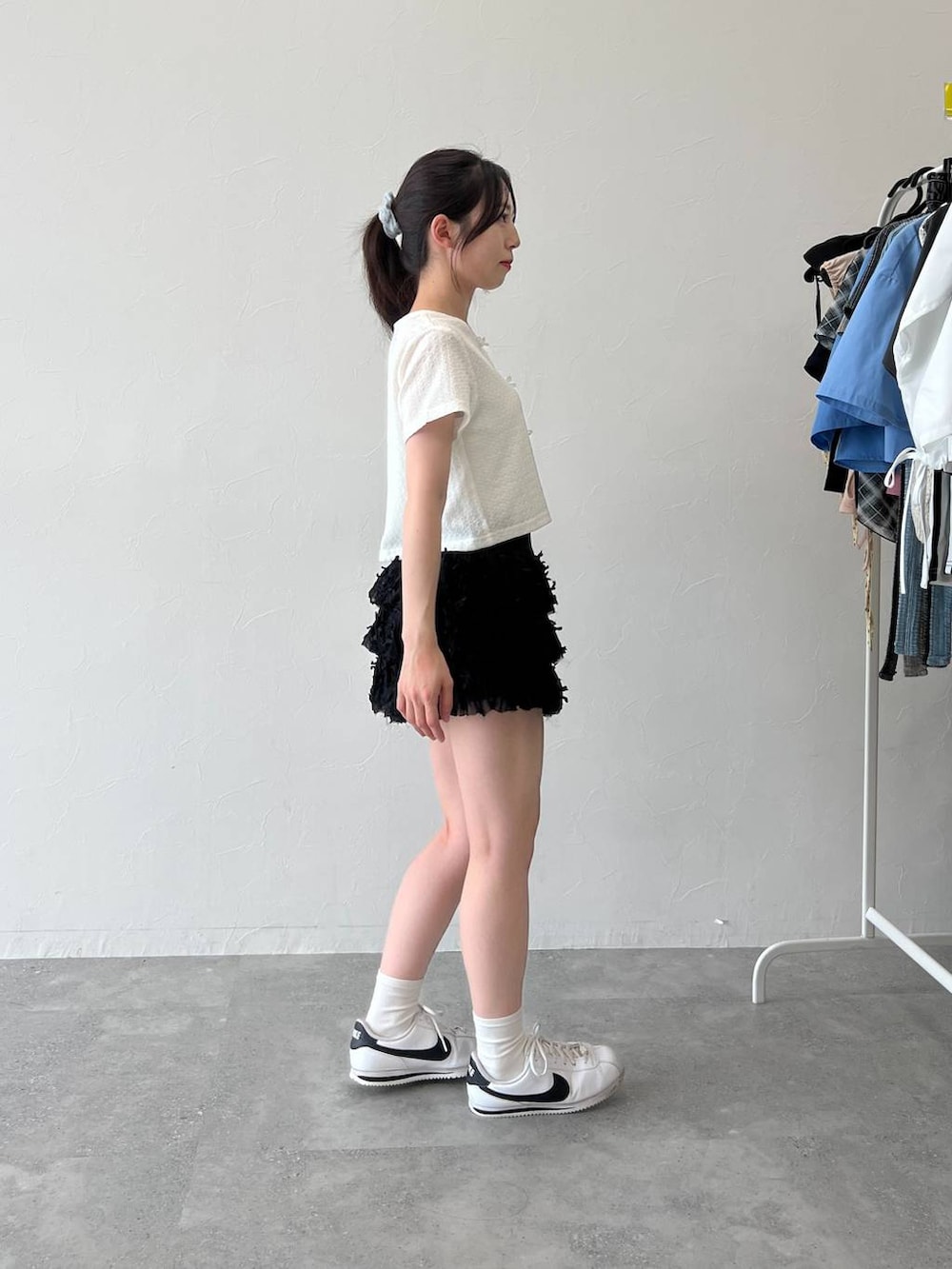 ホワイト系のTシャツ/カットソー、ブラック系のスカートを着用したレディースの夏コーディネートの4枚目の写真