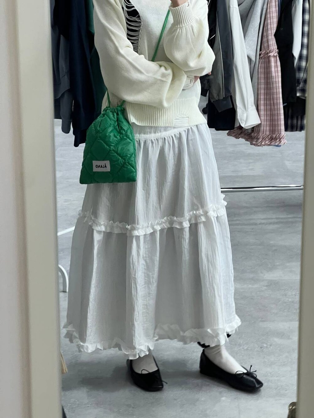 ホワイト系のニット/セーター、グリーン系のショルダーバッグ、ブラック系のスウェットパンツを着用したレディースの春コーディネートの7枚目の写真