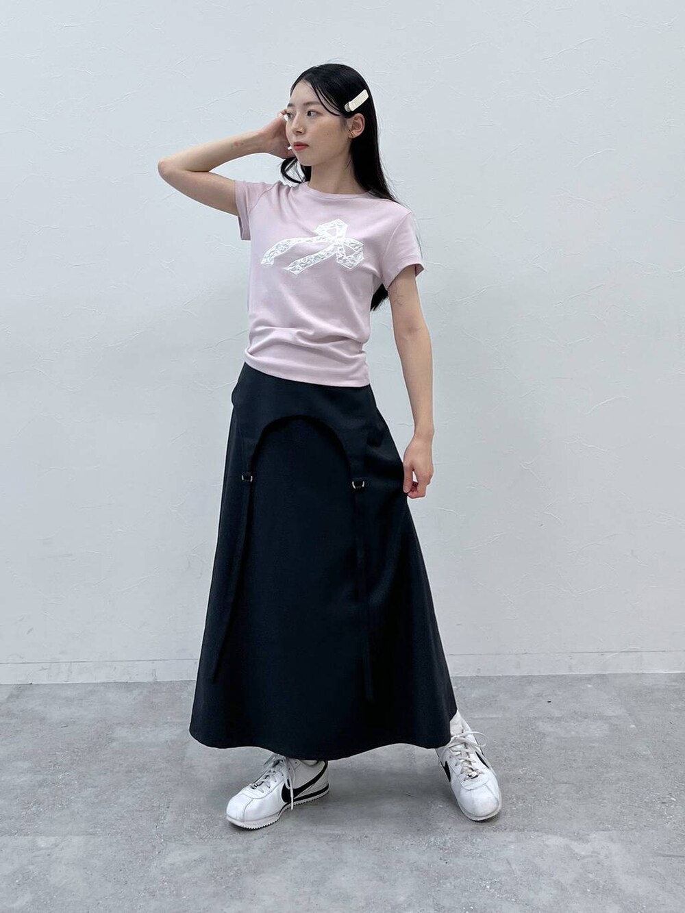 グレー系のスカート、ピンク系のTシャツ/カットソーを着用したレディースの夏コーディネートの2枚目の写真